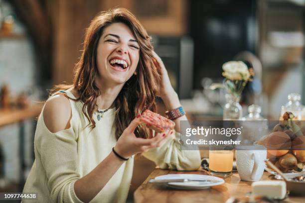 vrolijke jongedame ontbijten in de keuken. - young woman eating stockfoto's en -beelden