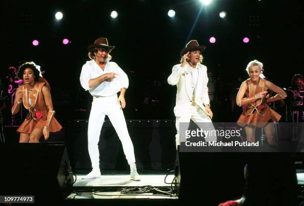 Helen 'Pepsi' Demacque, George Michael, Andrew Ridgeley and Shirlie Holliman of Wham performing on stage in 1985.
