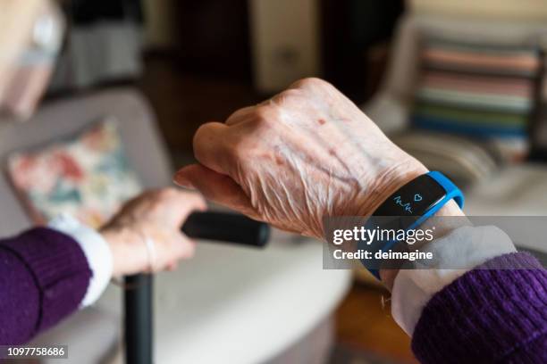 elderly woman hand and detail of the smartwatch - computador utilizável como acessório imagens e fotografias de stock