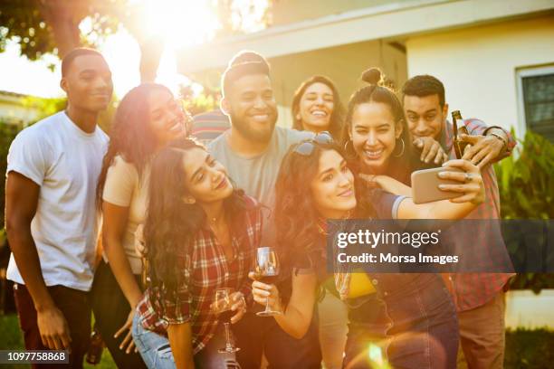 Happy Woman taking selfie with friends in party