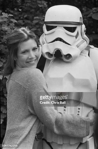 American actress, writer and comedian Carrie Fisher with a Stormtrooper, Star Wars fictional soldier, UK, 20th May 1980.