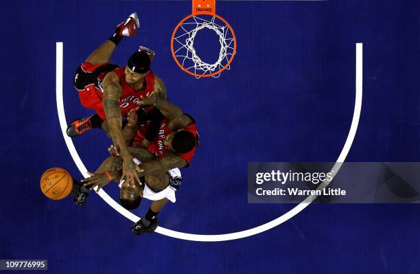 Damion James of the Nets jumps against James Johnson and Amir Johnson of the Raptors during the NBA match between New Jersey Nets and the Toronto...