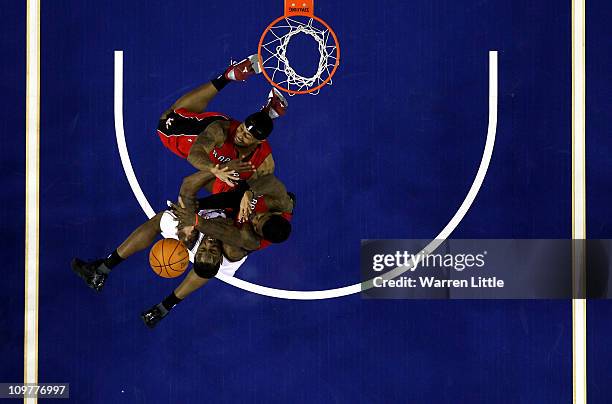 Damion James of the Nets jumps against James Johnson and Amir Johnson of the Raptors during the NBA match between New Jersey Nets and the Toronto...