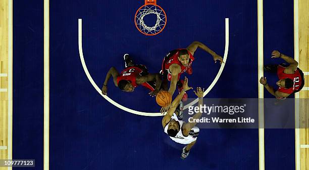 Sasha Vujacic of the Nets jumps against Alexis Ajinca and Ed Davis of the Raptors during the NBA match between New Jersey Nets and the Toronto...