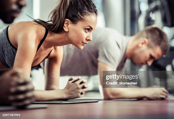 groep van atleten in een plank positie bij healthclub. - plank exercise stockfoto's en -beelden