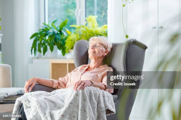 elderly lady resting in an armchair in her room - patient resting stock pictures, royalty-free photos & images