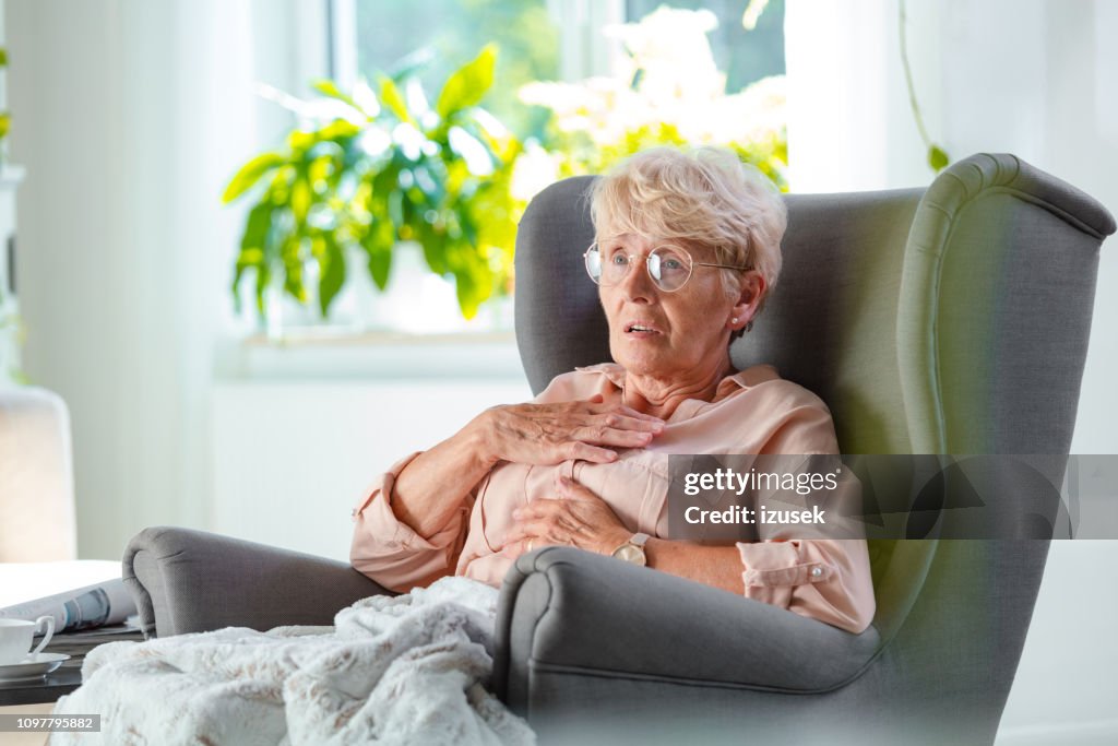 Worried elderly lady having pain in chest