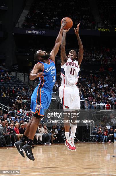 Jamal Crawford of the Atlanta Hawks shoots against James Harden of the Oklahoma City Thunder on March 4, 2011 at Philips Arena in Atlanta, Georgia....