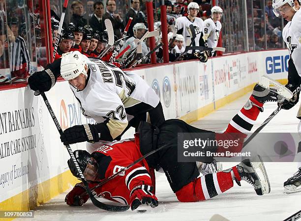 Alexei Kovalev of the Pittsburgh Penguins hits Dainius Zubrus of the New Jersey Devils to the ice at the Prudential Center on March 4, 2011 in...