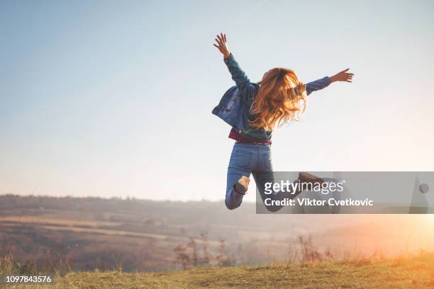 happy jump by girl in nature - joy stock pictures, royalty-free photos & images
