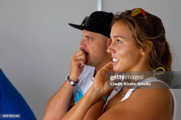 Sally Fitzgibbons of Australia watches the action replays on the big screen in the competitors area alongside Jake Patterson of Australia during the...