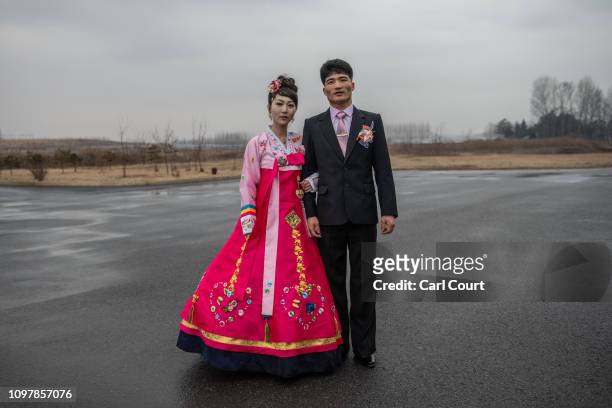 North Korean bride wearing a traditional Korean hanbok wedding dress poses for a photograph with the groom as they arrive for a wedding party at...