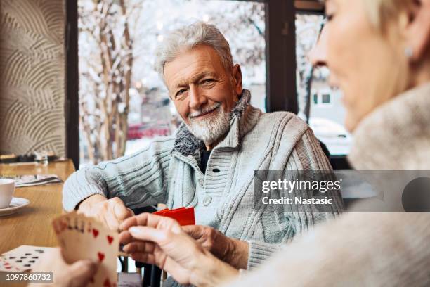 senior adult entertainment - senior men playing cards stock pictures, royalty-free photos & images