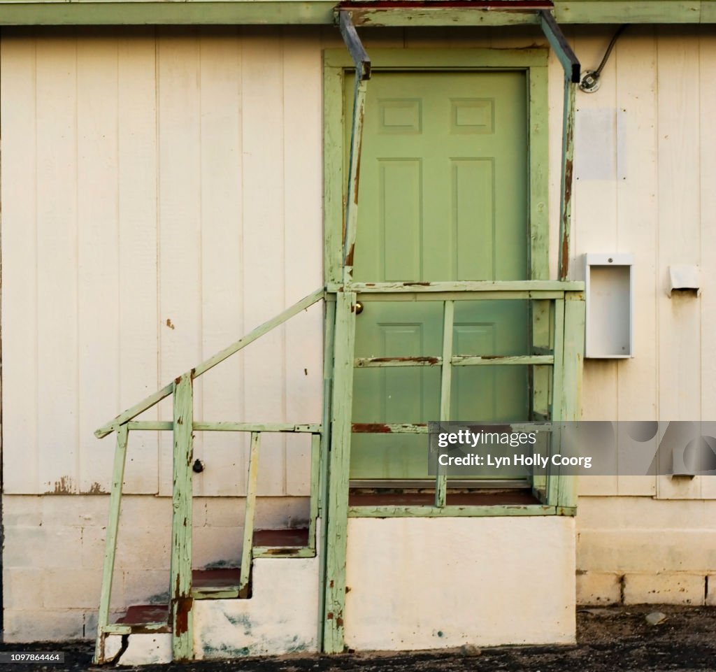 Green door and stairs of abandoned motel in USA