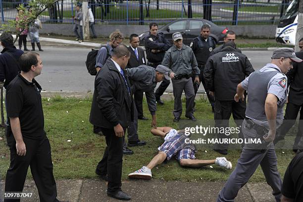 Drunk reveller lies on the ground handcuffed by militarized policemen after attemping to attack private security guards just outside a VIP area at...