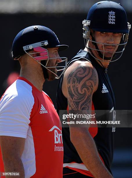 England cricketer Matt Prior talks with teammate Kevin Pietersen as they arrive to bat in the nets during a training session at the M.A. Chidambaram...