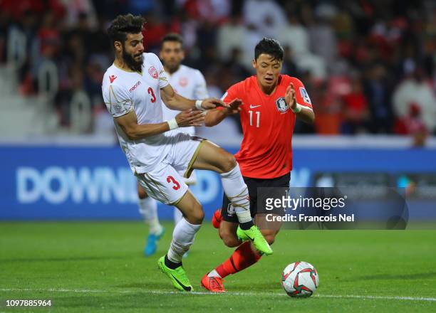 Hwang Hee-Chan of South Korea is challenged by Waleed Al Hayam of Bahrain during the AFC Asian Cup round of 16 match between South Korea and Bahrain...