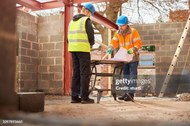 builder with apprentice - builder apprenticeship stock pictures, royalty-free photos & images