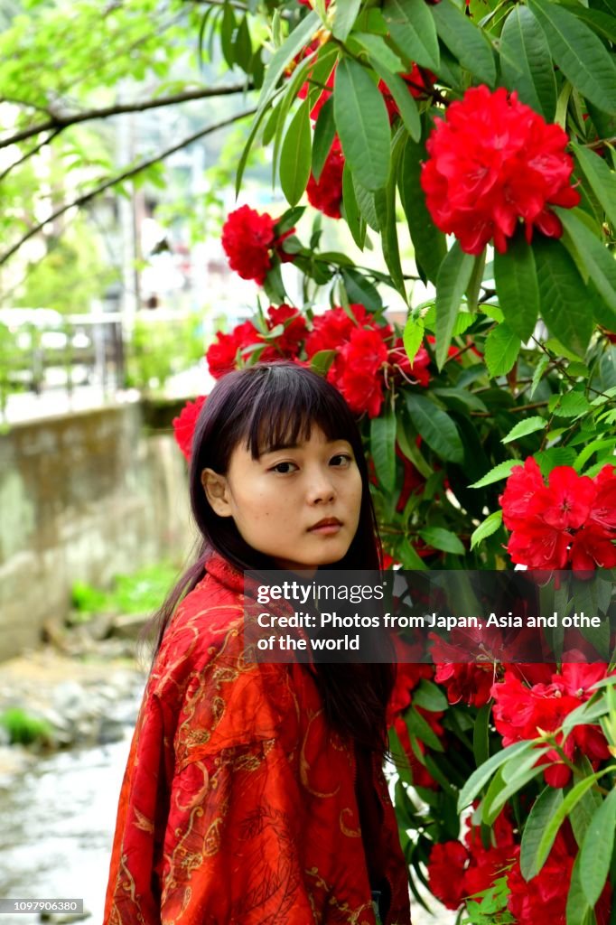 Young Japanese Woman and Red Rhododendron Flowers