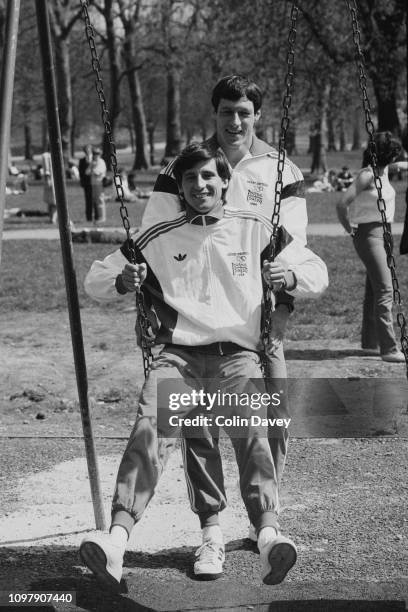 British track and field athlete Allan Wells pushes Sebastian Coe on a swing, UK, 24th April 1984.