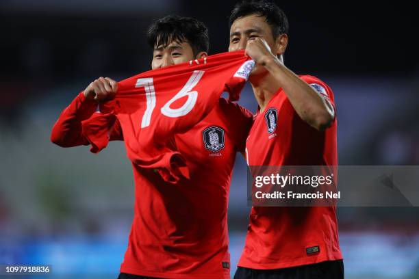 Son Heung-Min and Ji Dong-Won of South Korea celebrate with the shirt of injured team mate Ki Sung-Yueng as Kim Jin-Su scores their team's second...