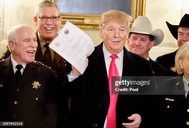 President Donald Trump jokes about a letter given to him by a sheriff after meeting with sheriffs from across the country in the Diplomatic Reception...