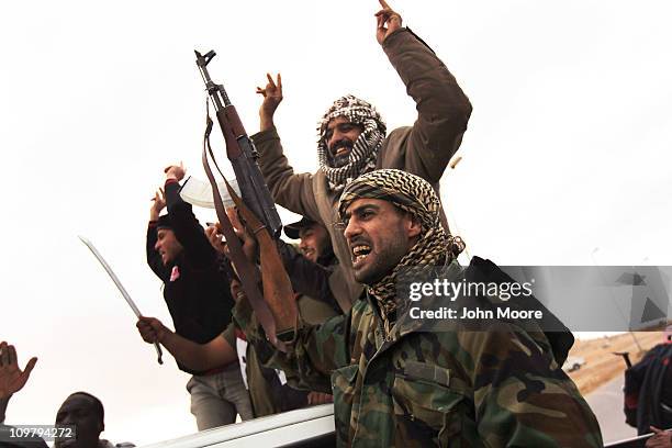 Rebel militiamen celebrate after capturing territory from government troops on March 25 2011 in Ben Jawat, Libya. Opposition forces pushed troops...
