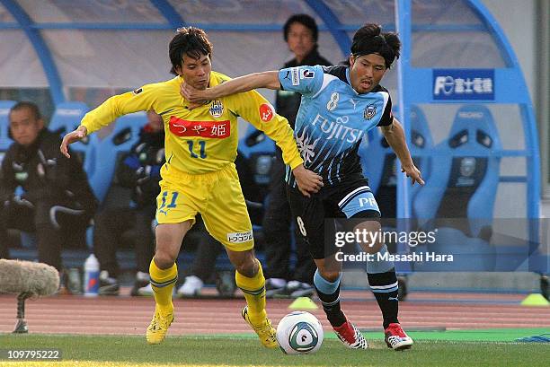 Takanobu Komiyama of Kawasaki Frontale and Tomotaka Kitamura of Montedio Yamagta compete for the ball during a J.League match at Todoroki Stadium on...