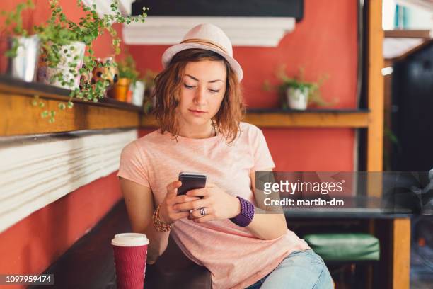 tienermeisje op café texting - bar girl stockfoto's en -beelden