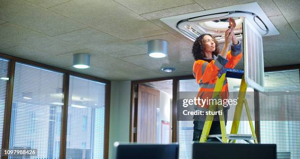 female air con maintenance engineer - ladder stock pictures, royalty-free photos & images