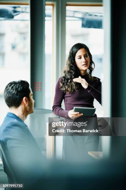 businesswoman holding digital tablet presenting data during project meeting in office - build presents the cast of transparent stockfoto's en -beelden