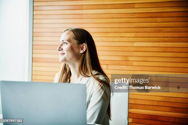 portrait of smiling businesswoman working on laptop during meeting in office - wisdom knowledge modern stockfoto's en -beelden