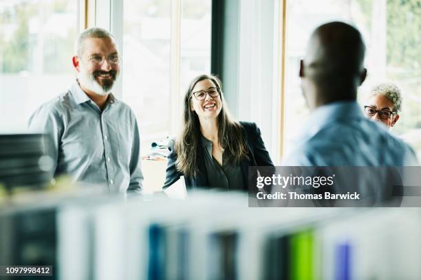 laughing colleagues in discussion during project meeting in creative studio - four day old stock pictures, royalty-free photos & images