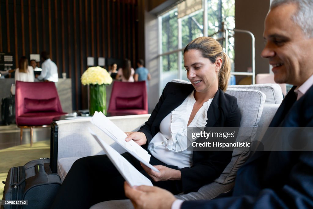 Successful business partners in a meeting at hotel lounge checking some documents