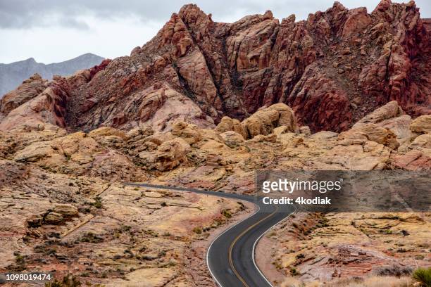 empty desert road on red rock canyon - southern nevada stock pictures, royalty-free photos & images
