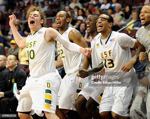 Marko Petrovic, Perris Blackwell, Moustapha Diarra and Rashad Green of the San Francisco Dons celebrate on the bench late in their 76-59 victory over...