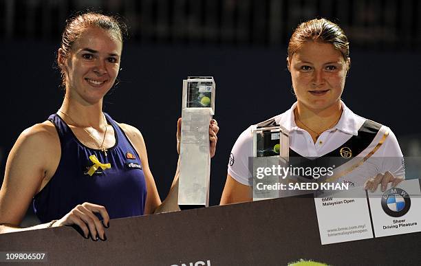 Dinara Safina of Russia and her partner Galina Voskoboeva of Kazakistan pose for pictures with the winning trophies during a prize distribution...