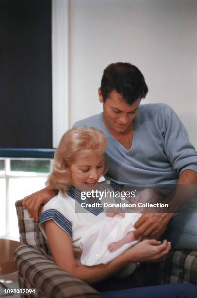 Actors Janet Leigh and Tony Curtis pose for a portrait with their baby daughter Kelly Curtis at home on August 4, 1956 in Los Angeles, California.