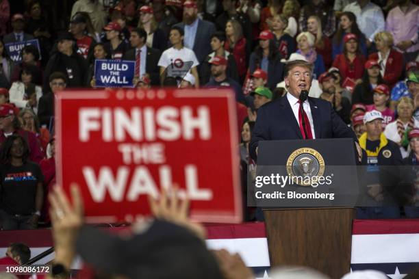 An attendee holds a banner reading "Finish the Wall" as U.S. President Donald Trump speaks during a rally in El Paso, Texas, U.S., on Monday, Feb....