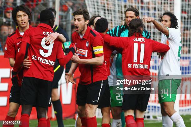 Goalkeeper Tim Wiese of Bremen argues with Yacine Abdessadki and Papiss Demba Cisse of Freiburg during the Bundesliga match between SC Freiburg and...