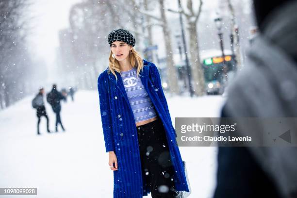 Veronika Heilbrunner, wearing a light blue Chanel top, black pants, blue coat and checked hat, is seen outside Chanel show during Paris Fashion Week...