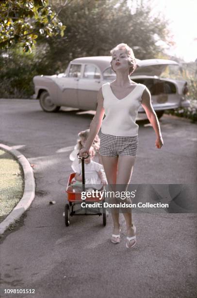 Actress Janet Leigh tows her daughters Jamie Lee and Kelly in a Radio Flyer at home on April 4, 1960 in Los Angeles, California.