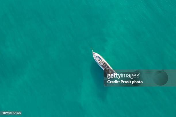 aerial top shot of a luxurious yacht on the sea - maldives boat stock pictures, royalty-free photos & images