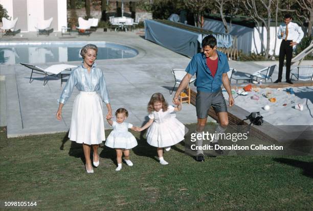 Actors Janet Leigh and Tony Curtis play with their daughters daughters Jamie Lee and Kellyby the pool at home on April 4, 1960 in Los Angeles,...