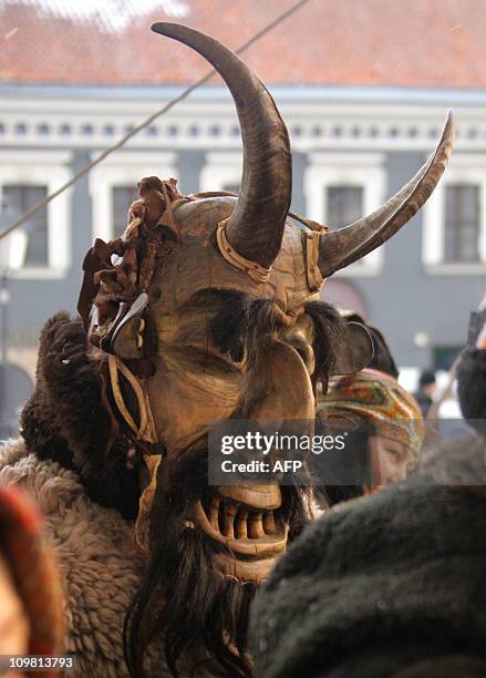 Revellers wearing masks and dressed as gypsies, horses, goats parade in the streets of the old town of Vilnius to celebrate Uzgavenes or 'the time...