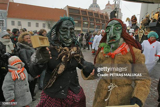 Revellers wearing masks and dressed as gypsies, horses, goats parade in the streets of the old town of Vilnius to celebrate Uzgavenes or 'the time...