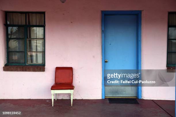 red chair and blue door at van horn, texas, usa - motel stock-fotos und bilder