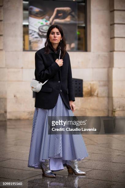 Deborah Reyner Sebag, wearing a dark blue blazer, long striped skirt, silver boots and white bag, is seen outside Alexis Mabille show during Paris...