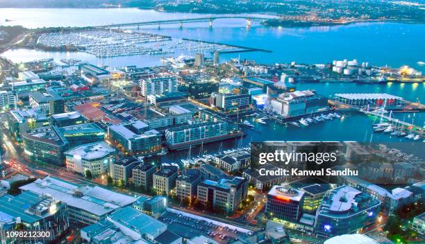 viaduct harbour at dush with auckland harbour bridge in background - auckland aerial stock pictures, royalty-free photos & images