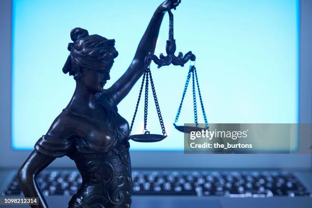 lady justice against laptop monitor - lady justice stockfoto's en -beelden